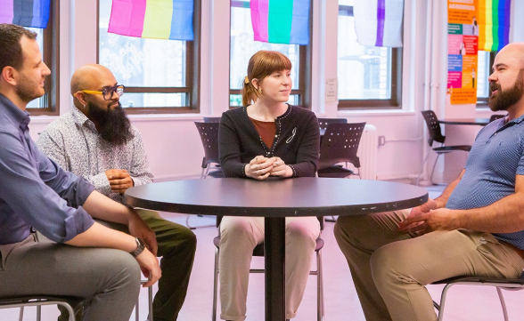 People sit and talk around a table.